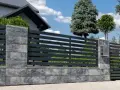Nowoczesne ogrodzenie betonowe z poziomymi, ciemnymi przęsłami. Zastanawiasz się, ile kosztuje ogrodzenie betonowe?
