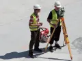 Dwóch geodetów pracuje na budowie. Zastanawiasz się, ile zarabia geodeta w Niemczech?