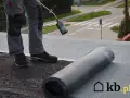 Pracownik wykonuje położenie papy na dachu. Sprawdź atrakcyjną cenę za m2!