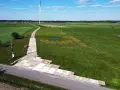 Teren budowy farmy wiatrowej z tymczasową drogą z płyt betonowych. Tłuczeń na drodze ułatwia dojazd ciężkiego sprzętu.