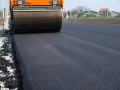Walec drogowy ubija świeży asfalt. Zastanawiasz się, ile kosztuje asfalt drogowy?