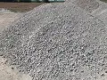 Duża hałda gresu pod kostkę. Zastanawiasz się, ile kosztuje tona grysu pod kostkę? Ten materiał budowlany jest kluczowy do wykonania trwałej podbudowy.
