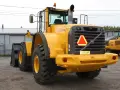 Żółta ładowarka kołowa Volvo L150F z tablicą rejestracyjną 123-ABF.