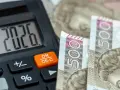 Kalkulator pokazuje 20,26, a obok leżą banknoty 500 zł. To może być odpowiedź na pytanie, ile zarabia pomocnik dekarza na godzinę.