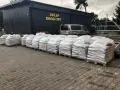 Silosy z materiałem drogowym przed sklepem. Zastanawiasz się, ile kosztuje tona asfaltu? Tu znajdziesz odpowiedź.
