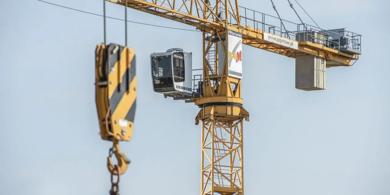 Żuraw samojezdny Liebherr na budowie. Operator steruje maszyną z kabiny. Zastanawiasz się, ile zarabia operator żurawia samojezdnego?