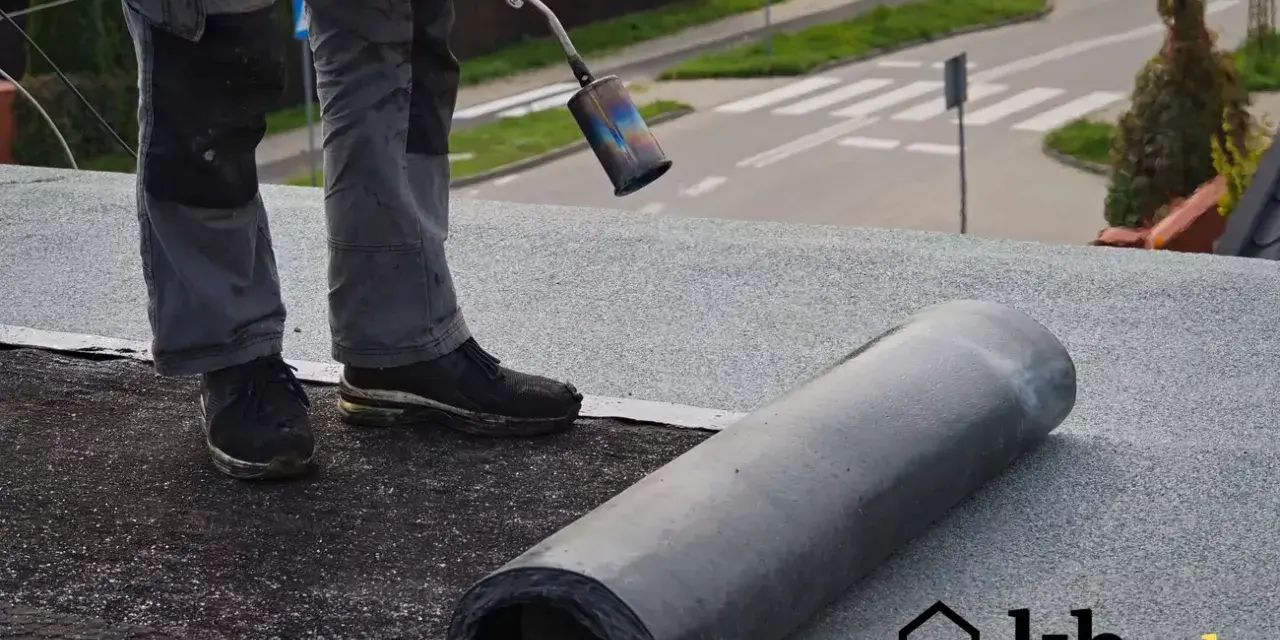 Pracownik wykonuje położenie papy na dachu. Sprawdź atrakcyjną cenę za m2!