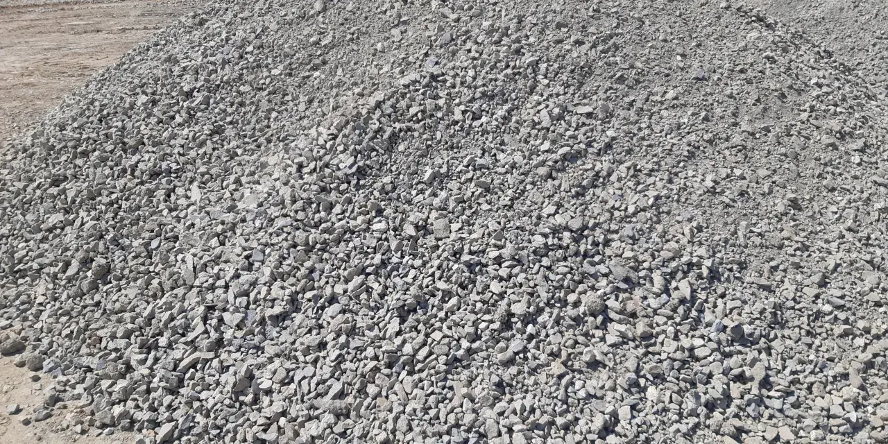 Duża hałda gresu pod kostkę. Zastanawiasz się, ile kosztuje tona grysu pod kostkę? Ten materiał budowlany jest kluczowy do wykonania trwałej podbudowy.