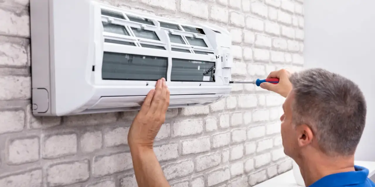 Fachowiec montuje klimatyzację w mieszkaniu. Poznaj koszt instalacji i ciesz się komfortem.