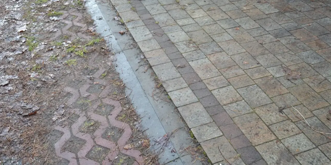 Podbudowa pod kostkę brukową na glinie, z widocznym wzorem ażurowym i kamieniami.