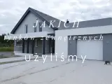Nowoczesny dom z szarą elewacją i białym garażem. Tynk zewnętrzny typu baranek nadaje mu unikalny charakter.