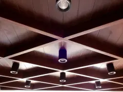 Drewniane, kratownicowe **stare kasetony na suficie** z wbudowanymi reflektorami tworzą geometryczny wzór.