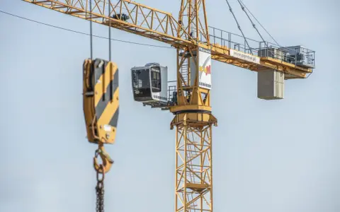 Żuraw samojezdny Liebherr na budowie. Operator steruje maszyną z kabiny. Zastanawiasz się, ile zarabia operator żurawia samojezdnego?