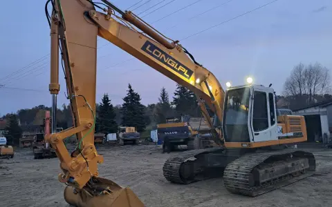 Żółta koparka gąsienicowa Liebherr z napisem LONGI.PL gotowa do pracy. Dostępna do wynajęcia.