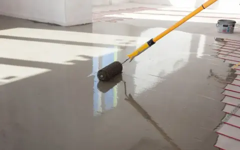Wylewki maszynowe cena za m2 z materiałem. Wałek dociskowy rozprowadza świeżą masę po podłodze z ogrzewaniem podłogowym.