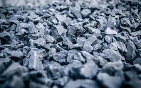 Głęboki, szary żwir do betonu, ułożony w dużą hałdę. Kamienie są ostre i nieregularne, tworząc teksturę idealną do budowy.
