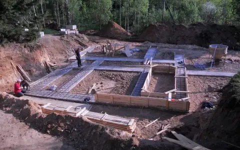 Budowa fundamentu pod dom. Zbrojenie i szalunki czekają na beton.