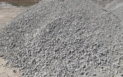 Duża hałda gresu pod kostkę. Zastanawiasz się, ile kosztuje tona grysu pod kostkę? Ten materiał budowlany jest kluczowy do wykonania trwałej podbudowy.