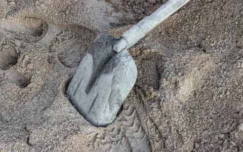 Łopata w piasku, ślady opon. Ile piasku na m3 betonu? To pytanie zadaje sobie każdy budowlaniec.