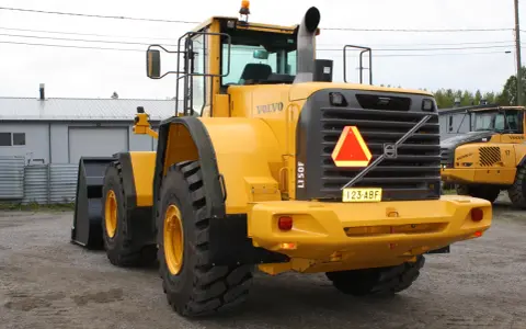 Żółta ładowarka kołowa Volvo L150F z tablicą rejestracyjną 123-ABF.