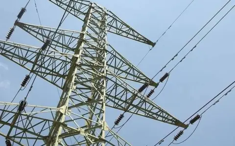 Wysoki maszt energetyczny z przewodami, przypominający o konieczności zachowania bezpieczna odległość od linii wysokiego napięcia 400 kv.