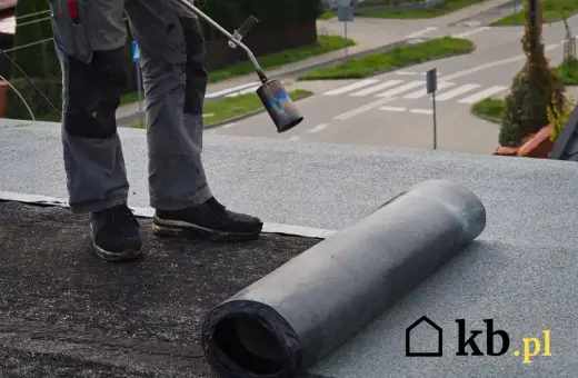 Pracownik wykonuje położenie papy na dachu. Sprawdź atrakcyjną cenę za m2!