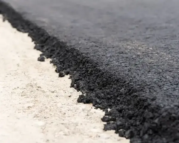 Świeżo położony asfalt na drodze. Sprawdź położenie asfaltu cennik, aby zaplanować budowę lub remont.