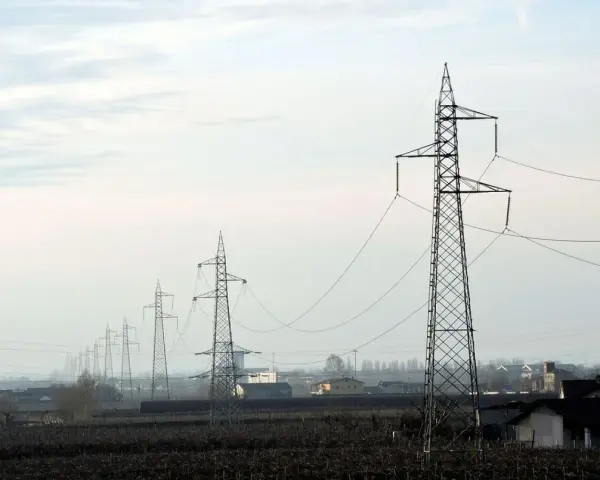 Linia wysokiego napięcia 110 kV biegnie przez krajobraz. Zachowanie bezpiecznej odległości od niej jest kluczowe dla ochrony.