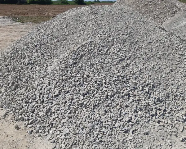 Duża hałda gresu pod kostkę. Zastanawiasz się, ile kosztuje tona grysu pod kostkę? Ten materiał budowlany jest kluczowy do wykonania trwałej podbudowy.