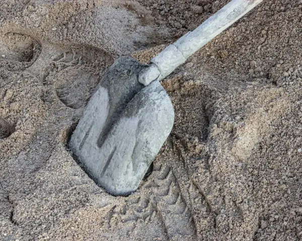 Łopata w piasku, ślady opon. Ile piasku na m3 betonu? To pytanie zadaje sobie każdy budowlaniec.