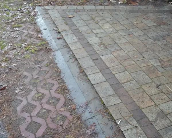 Podbudowa pod kostkę brukową na glinie, z widocznym wzorem ażurowym i kamieniami.