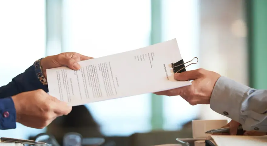 Dwie osoby przekazują sobie dokument "PARTNERSHIP AGREEMENT". To ważny moment, być może ustalanie co to dtr w umowie.