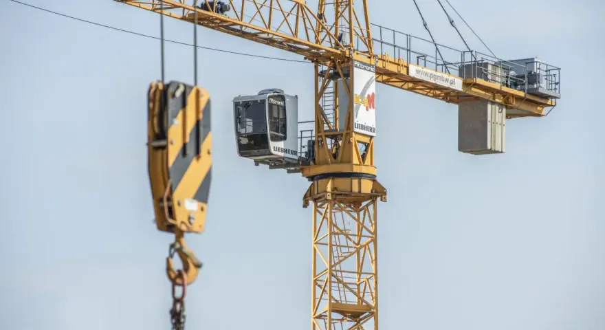 Żuraw samojezdny Liebherr na budowie. Operator steruje maszyną z kabiny. Zastanawiasz się, ile zarabia operator żurawia samojezdnego?
