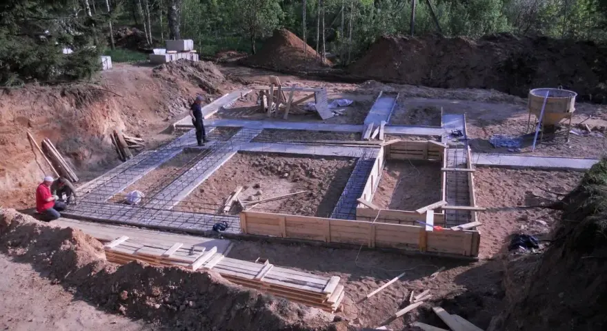 Budowa fundamentu pod dom. Zbrojenie i szalunki czekają na beton.