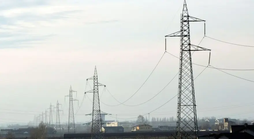 Linia wysokiego napięcia 110 kV biegnie przez krajobraz. Zachowanie bezpiecznej odległości od niej jest kluczowe dla ochrony.