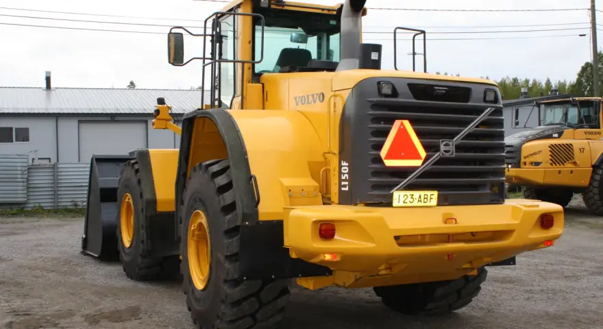 Żółta ładowarka kołowa Volvo L150F z tablicą rejestracyjną 123-ABF.