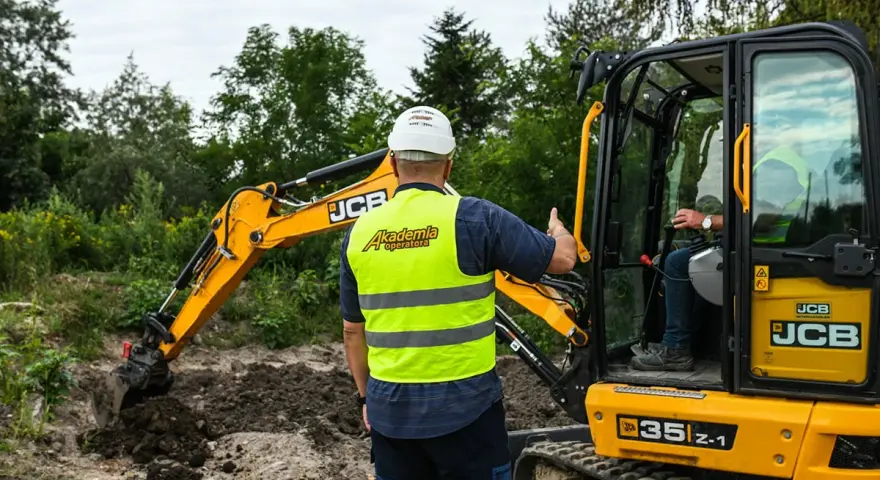 Instruktor z "Akademii Operatora" pokazuje, ile trwa kurs na koparkę, podczas szkolenia praktycznego.
