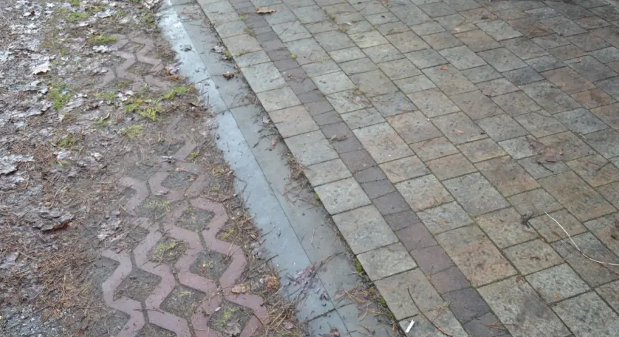 Podbudowa pod kostkę brukową na glinie, z widocznym wzorem ażurowym i kamieniami.