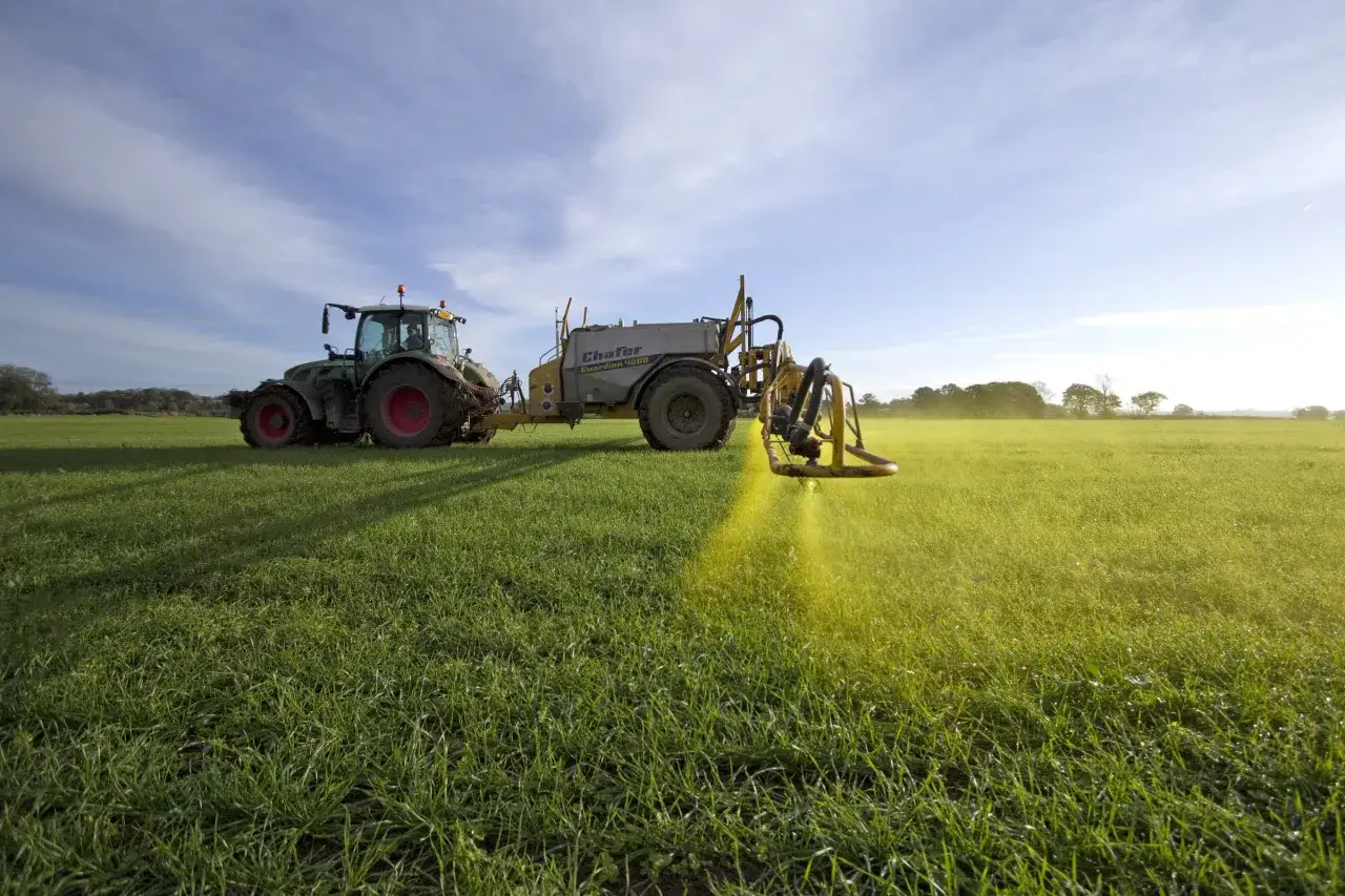 Traktor z opryskiwaczem Chafer Guardian 4000 na polu. Opryskuje trawę, tworząc żółtą smugę. Pytanie o roundup jakie proporcje jest kluczowe dla efektywności zabiegu.