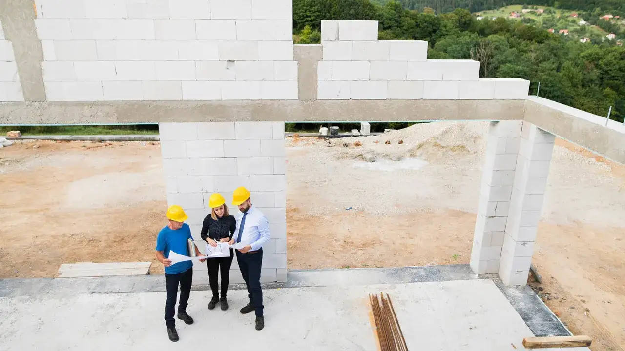Architekci omawiają plany budowy domu z bloczków silikatowych.