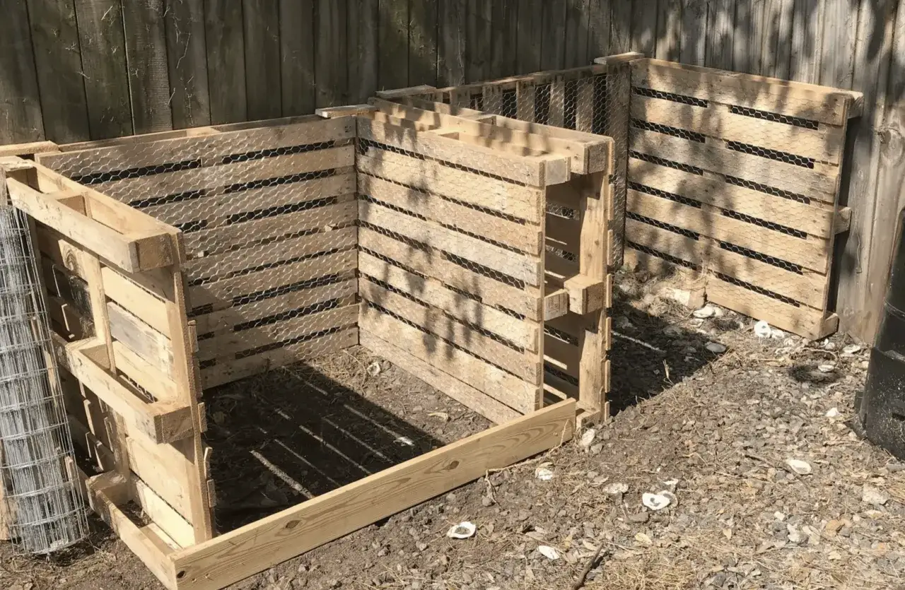 Kompostownik z palet, z siatką drucianą, gotowy do przyjęcia resztek organicznych.